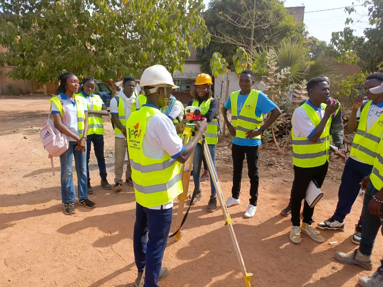 Étudiants de IPAM BURKINA manipulant un niveau topographique sur le terrain